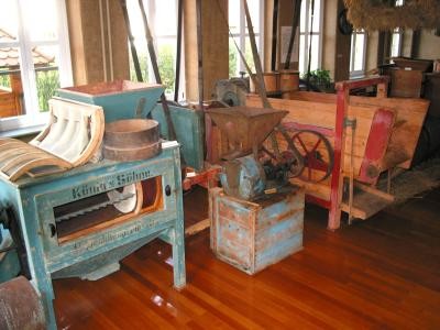 Bild vom Innenraum des Bauernmuseums Ostdorf mit diversen alten Geräten z.B. Getreidemühlen
