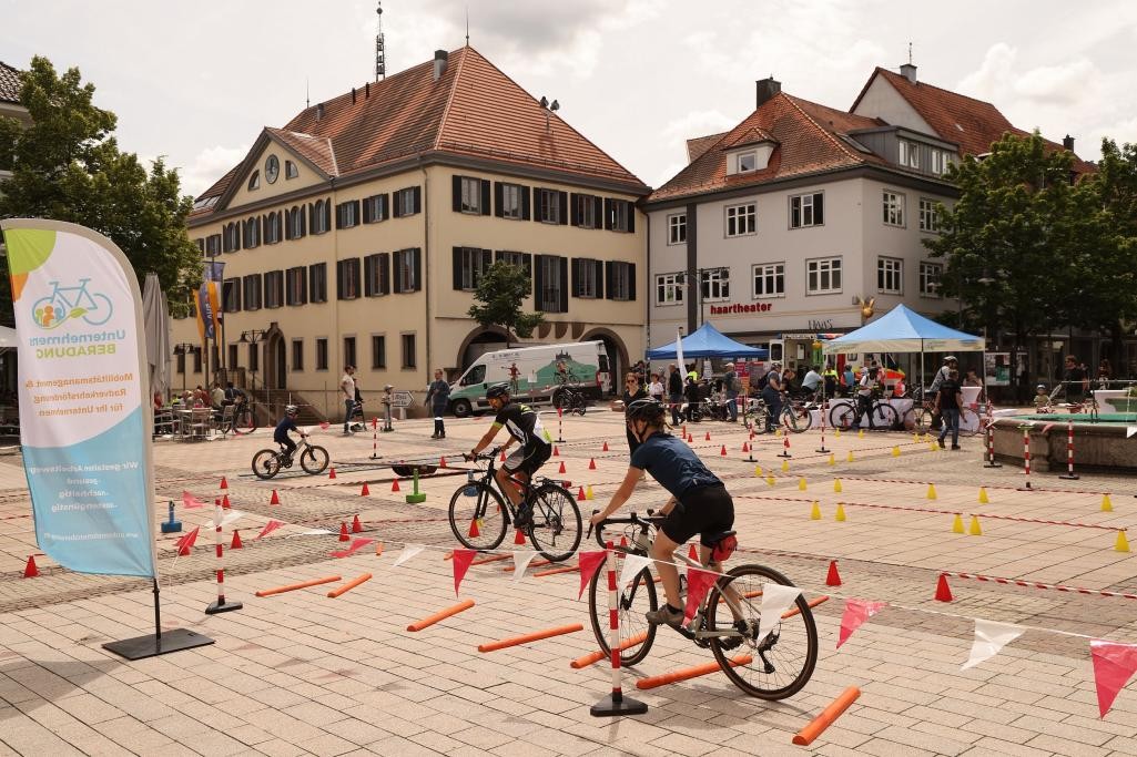 Zwei Radfahrer auf einem großen Platz durchfahren einen Parkour