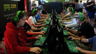 viele computerspielende junge Menschen sitzen sich in Reihen gegenüber