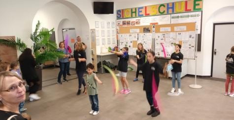 Kinder präsentieren ein Tanzprojekt in der Aula der Sichelschule