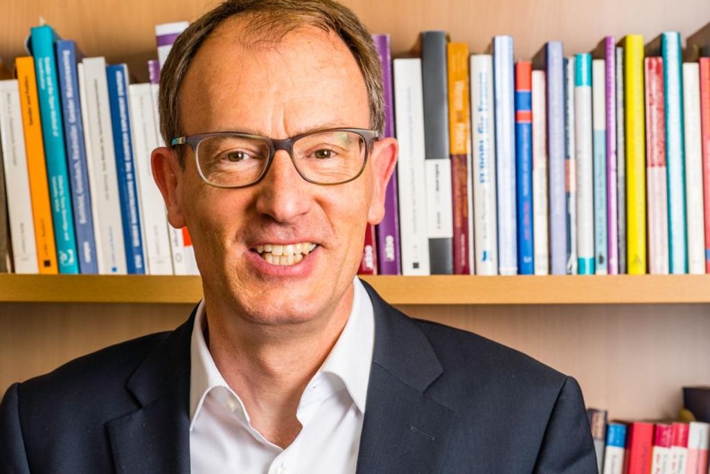 Dr. Martin Große Hüttmann vor einem Bücherregal