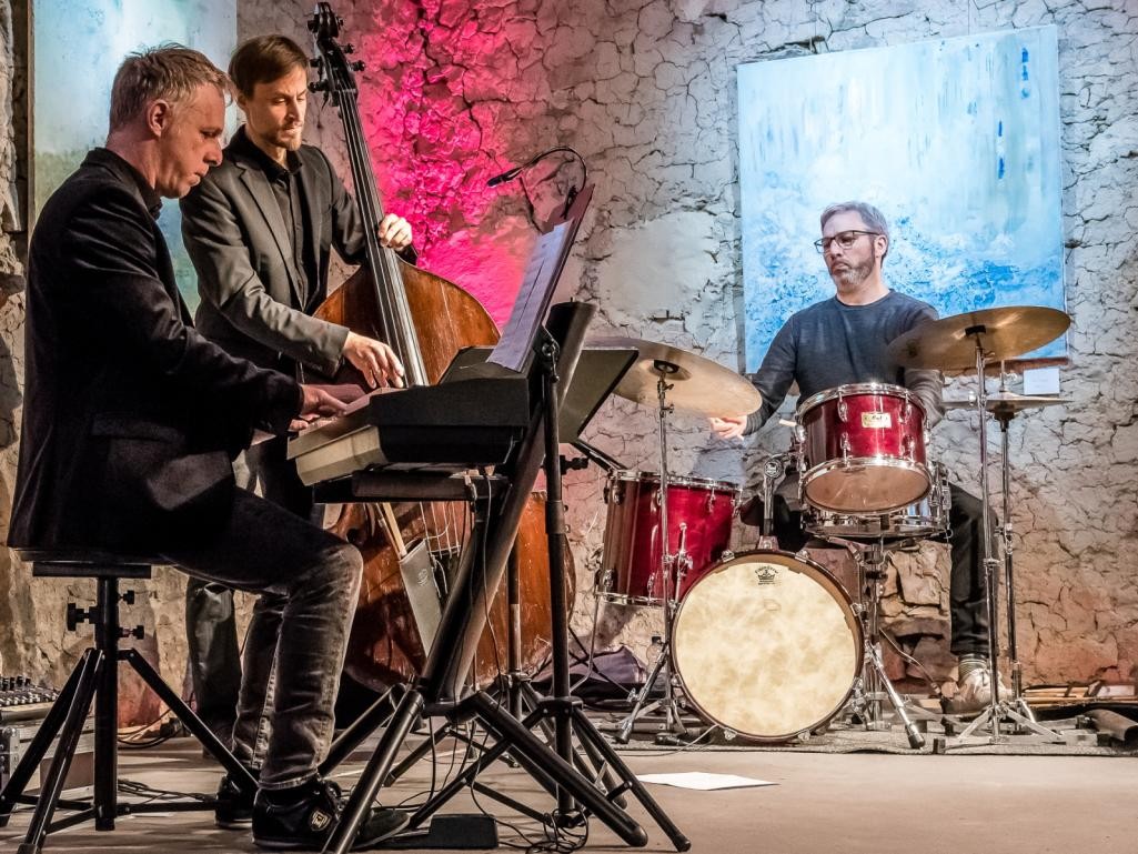 Drei Männer mit E-Piano, Kontrabass und Schlagzeug