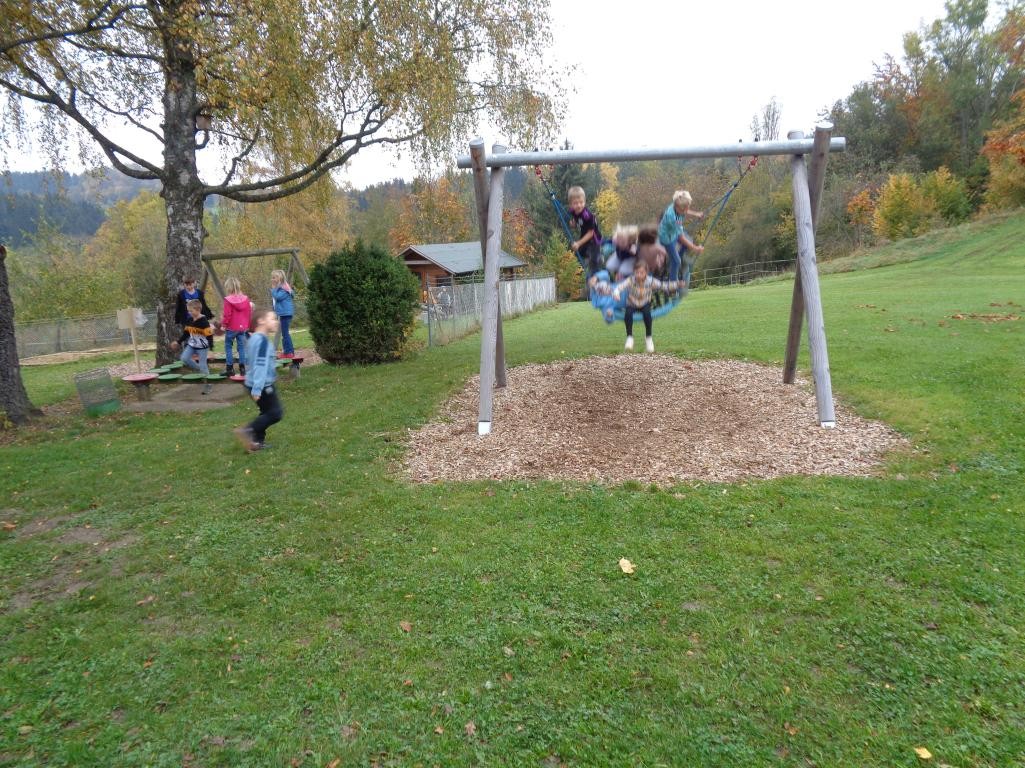Die Kinder am Spielen und Schaukeln