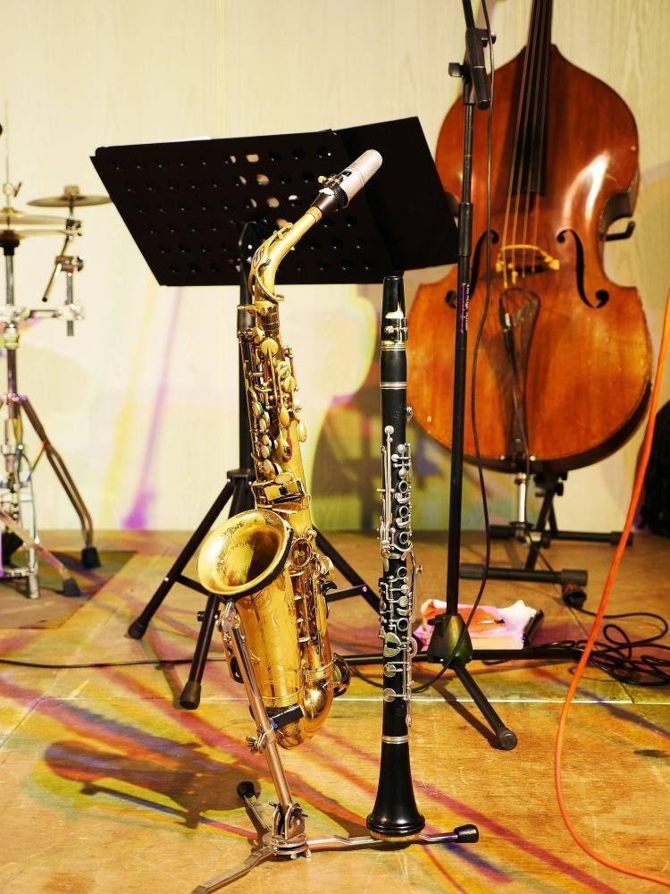 Ein Saxofon, eine Klarinette ein Cello stehen auf einer Bühne