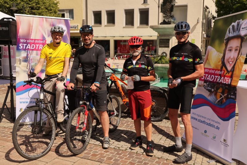 Fahrradfahrer mit zwei Fahrräder vor dem Plakat Stadtradeln Fahrradfahrer mit zwei Fahrräder vor dem Plakat Stadtradeln