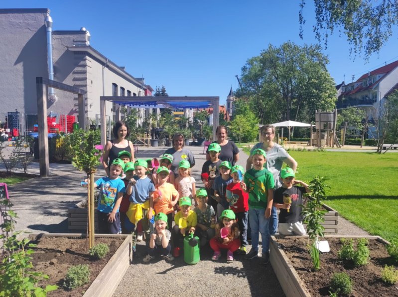 Kinder und Erwachsene stehen an den Hochbeeten