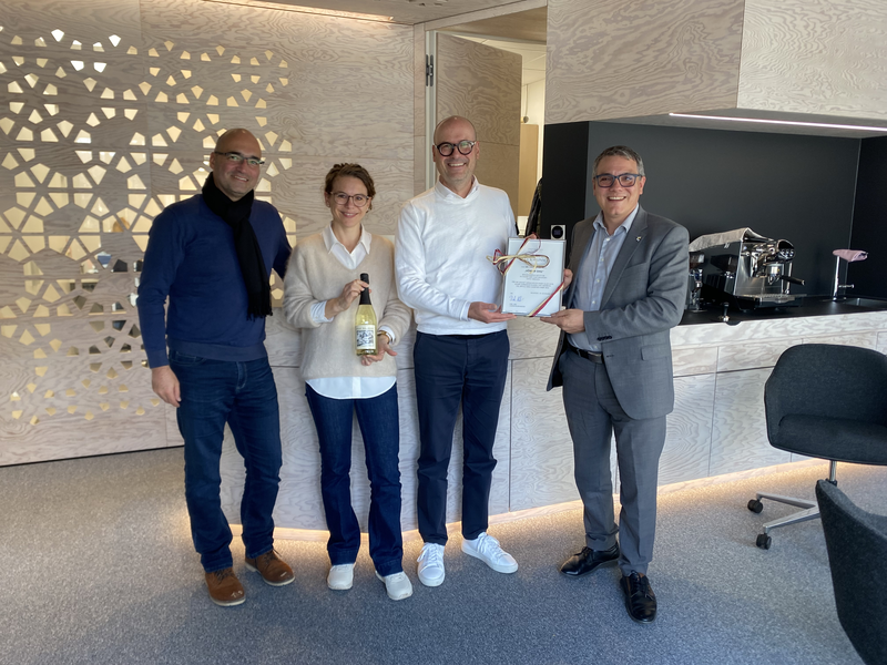 Vier Personen (drei Männer und eine Frau) stehen im Einzelhandelsgeschäft Hörbar