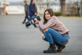 Frau kniet mit Kamera