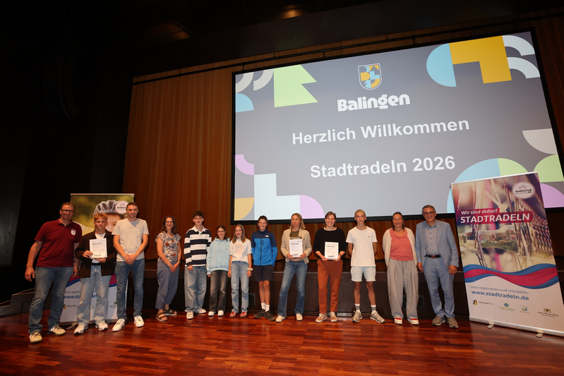 Menschen stehen auf der Bühne und freuen sich über die Gewinne