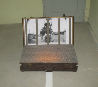 Werk "Kofferbomben" ein alter geöffneter Koffer, im Deckel ein Bild aus dem KZ Schömberg